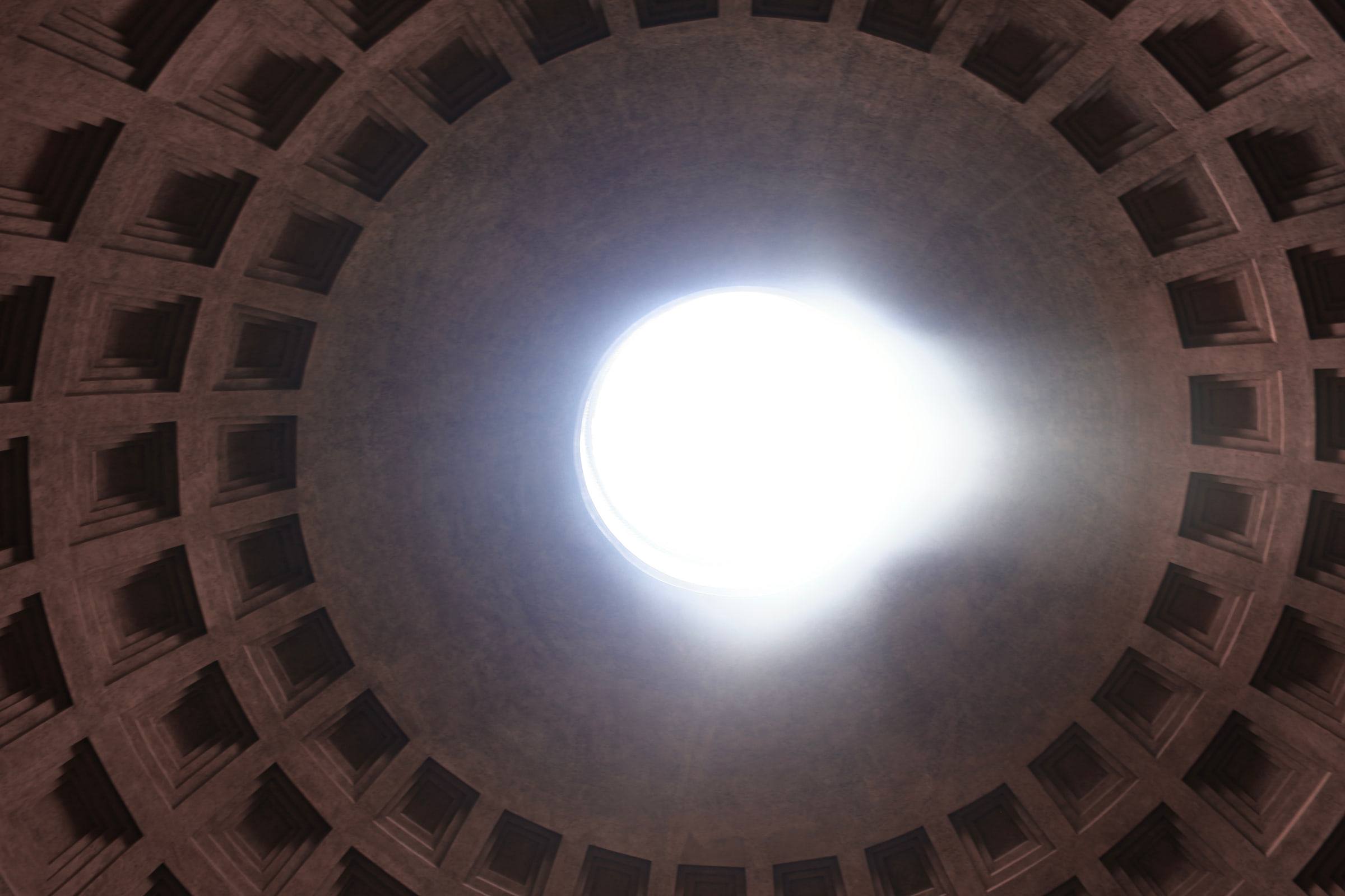 The open oculus of the Pantheon seen straight up, the coffered dome around it.